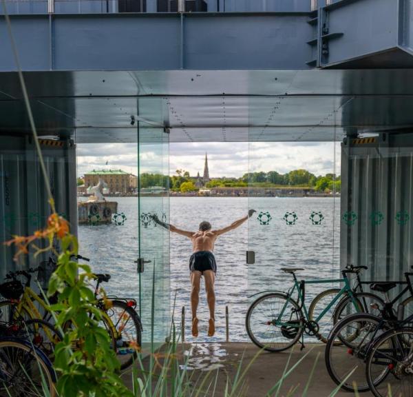A man swims from the Urban Rigger student housing block designed by Bjarke Ingels Group in Copenhagen, Denmark